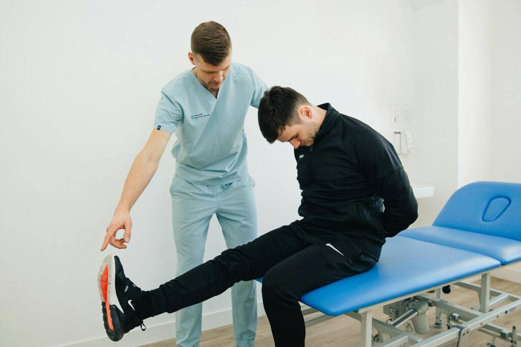 Chiropractor running sciatica tests on young man